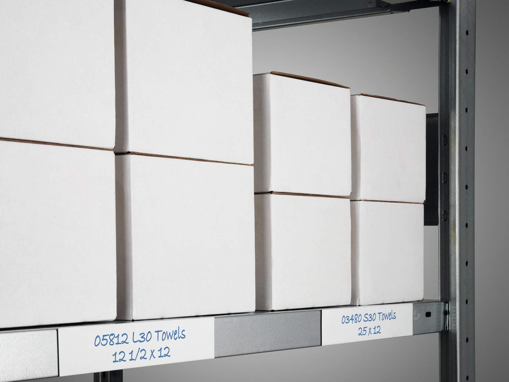 Two wide white magnetic tape labels written in blue on a steel shelf edge