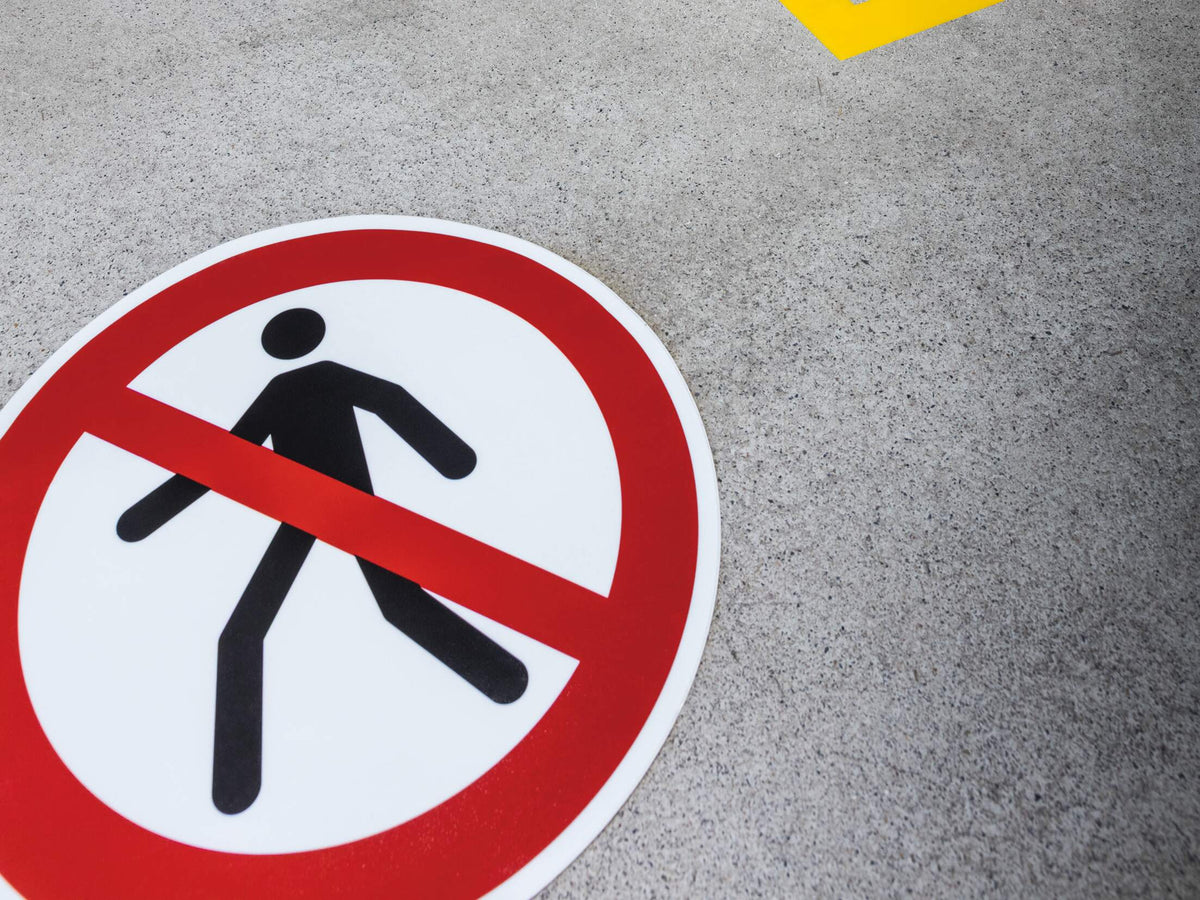 Durable pedestrians prohibited sign laid on a grey floor