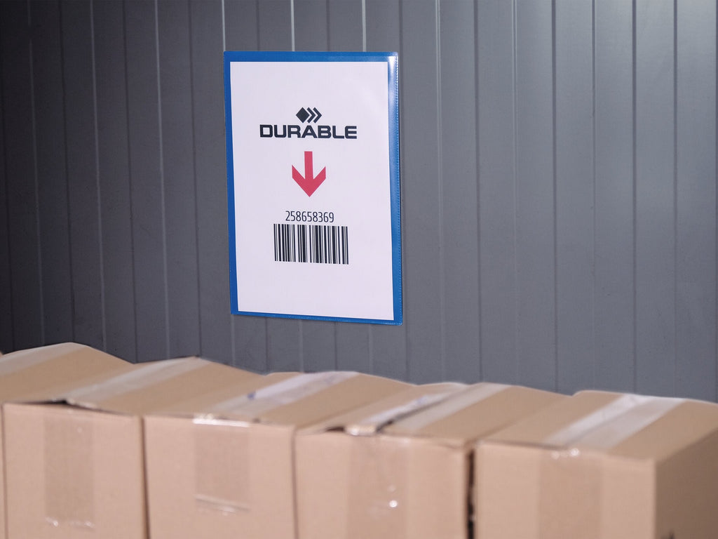 Durable A4 portrait magnetic pouch with a barcode sheet on a grey metal wall above stacked cartons