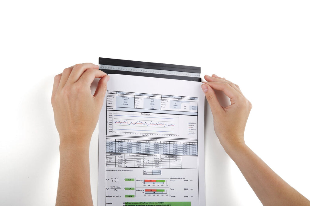 Hands sliding a data sheet under a Durable Durafix rail fixed to a white wall