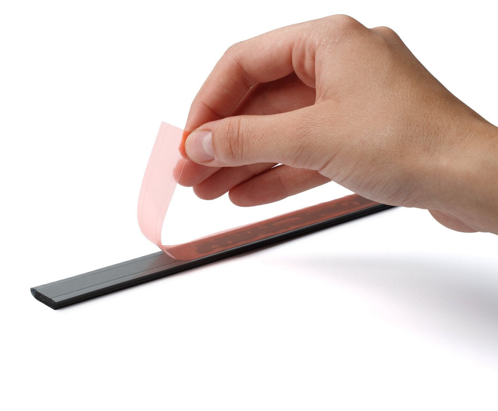Hand peeling the red backing liner off the self-adhesive back of a Durable Durafix rail