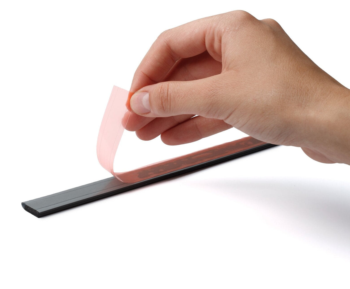 Hand peeling the red backing liner off the self-adhesive back of a Durable Durafix rail