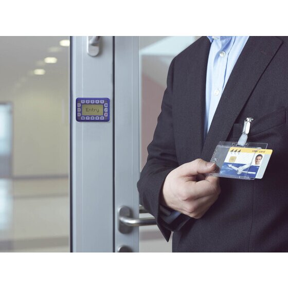 Person in a suit holding a clip-on pass holder up to a door access reader
