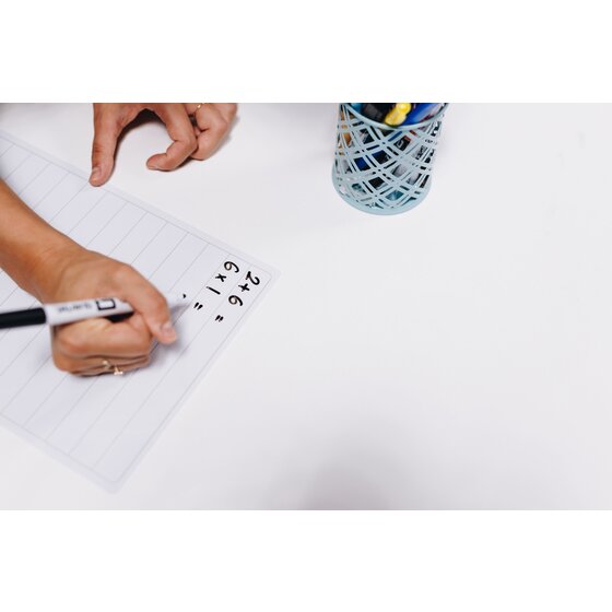 Hand writing sums with a marker on the lined side of a Quartet Flex A4 board