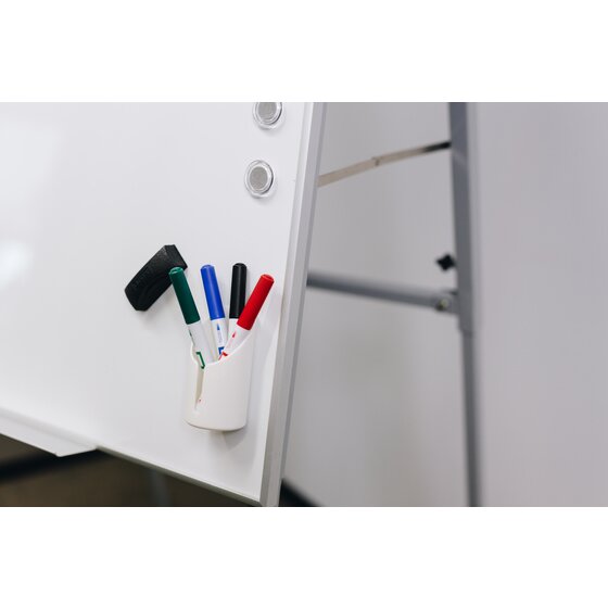 White Quartet accessory cup QTACCCUP with 4 markers and a black mini eraser on the edge of a whiteboard on an easel stand