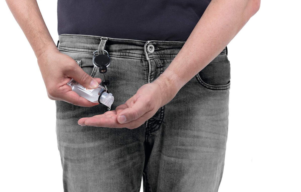 Hands squeezing gel from a bottle held on a Durable retractable reel clipped at the belt