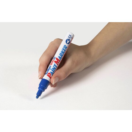 Hand writing with a blue Artline 400XF paint marker on a pale grey surface