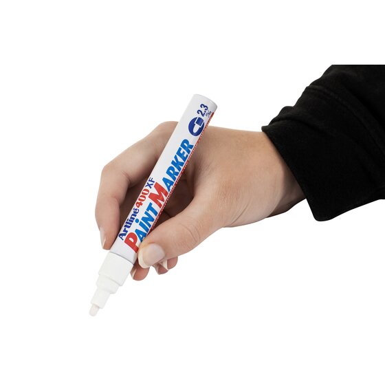 Hand in a black sleeve writing with a white Artline 400XF paint marker
