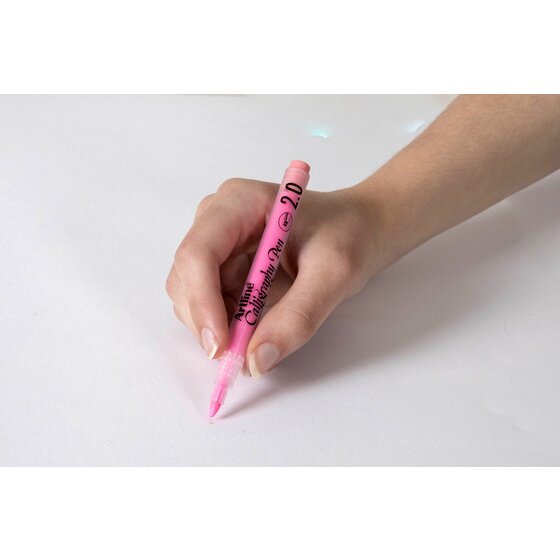 Hand writing with a pastel pink Artline Calligraphy Pen 2.0